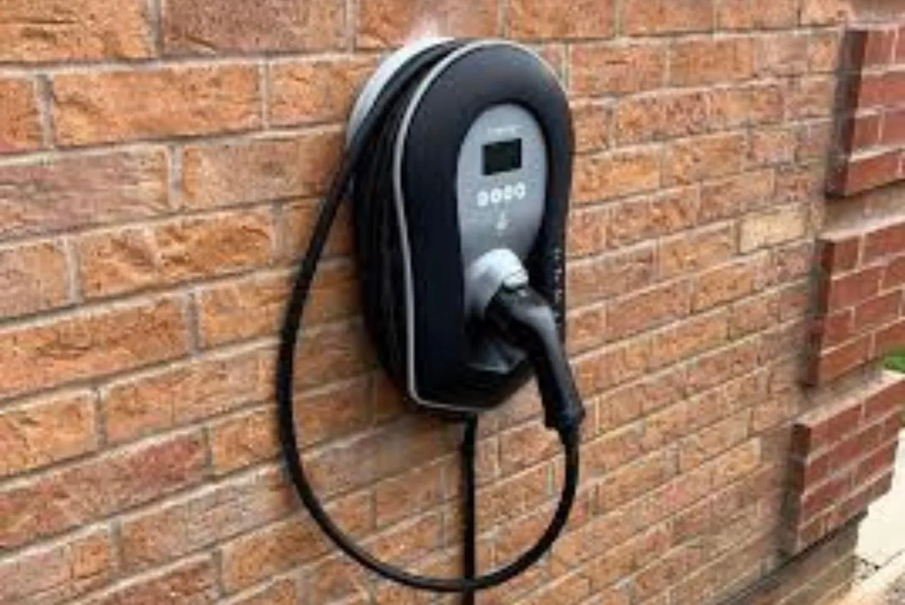 Home EV charger fitted to an exterior wall with its charging cable arranged neatly