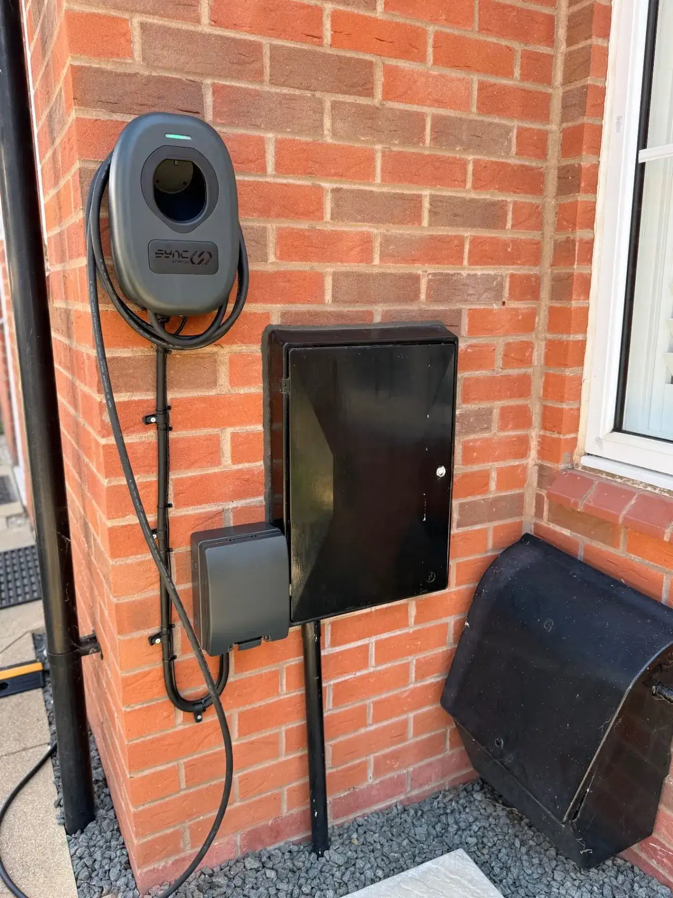 Sync Energy EV charger installed neatly on the outside wall of a home