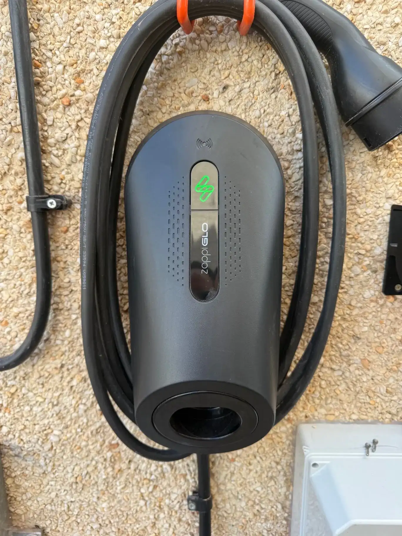 Black Zappi EV charger mounted neatly on a home exterior wall