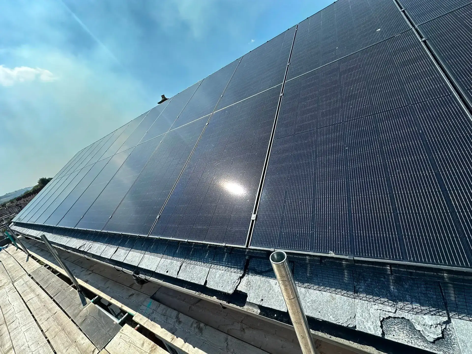 Dark solar panels covering a pitched roof with bird guard fitted along the roof edge