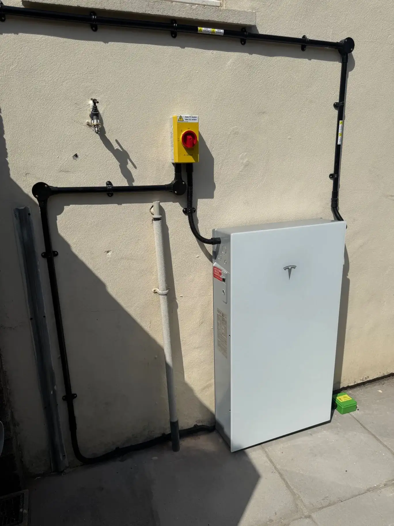 Tesla Powerwall and Gateway mounted on an exterior wall