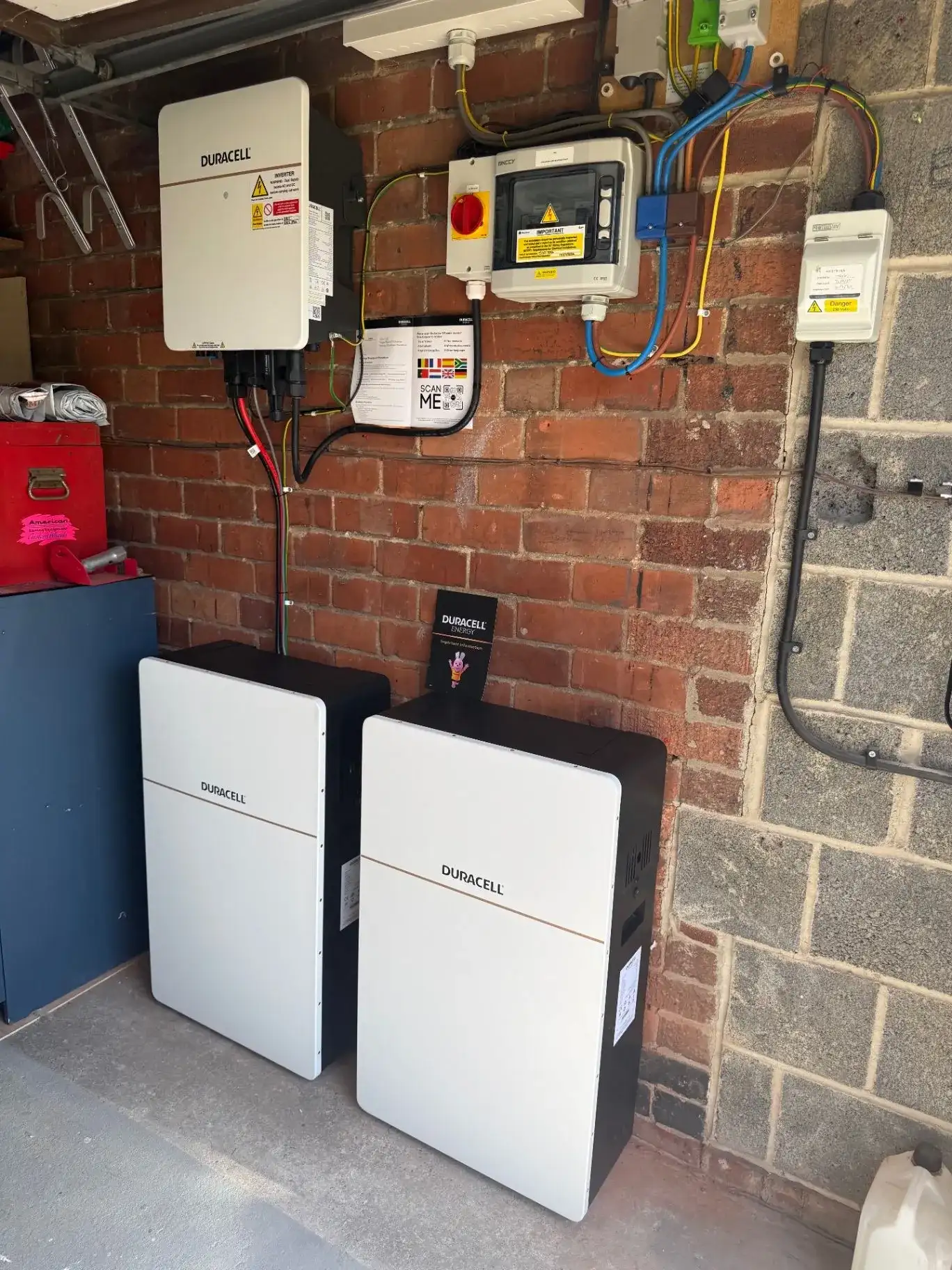 Duracell inverter and two battery storage units professionally installed against a brick wall